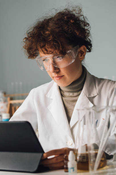 istock Woman Scientist in a Lab Coat Using a Digital Tablet During Research 1259302410