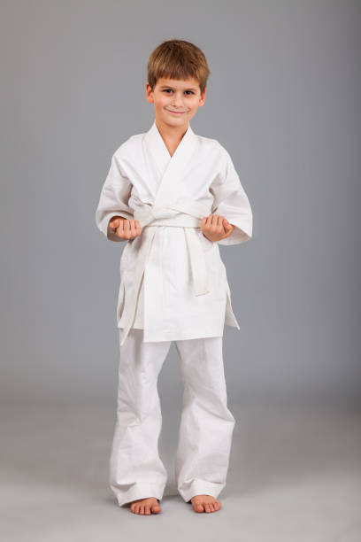 istock Karate boy in white kimono fighting 1259323656