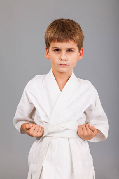 istock Karate boy in white kimono fighting 1259323660