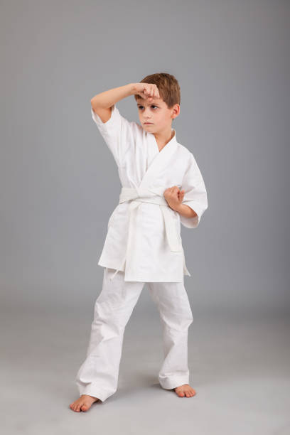 istock Karate boy in white kimono fighting 1259323663