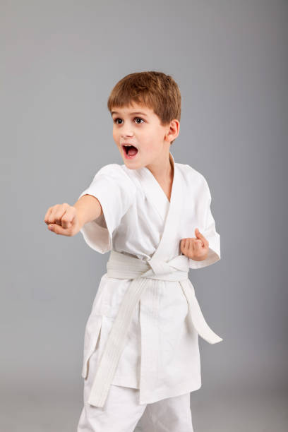 istock Karate boy in white kimono fighting 1259324689