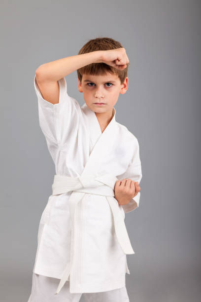 istock Karate boy in white kimono fighting 1259325734