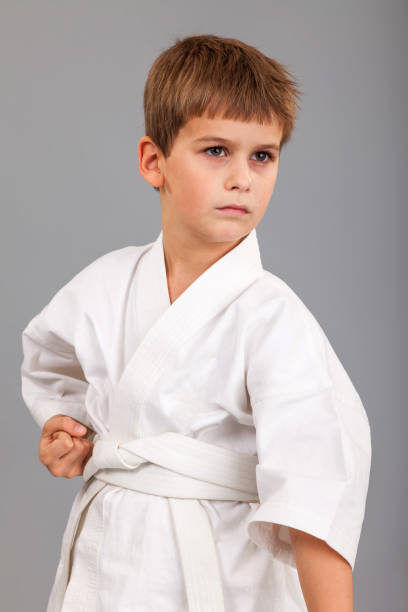 istock Karate boy in white kimono fighting 1259326239