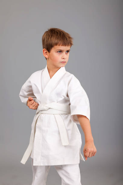 istock Karate boy in white kimono fighting 1259326246
