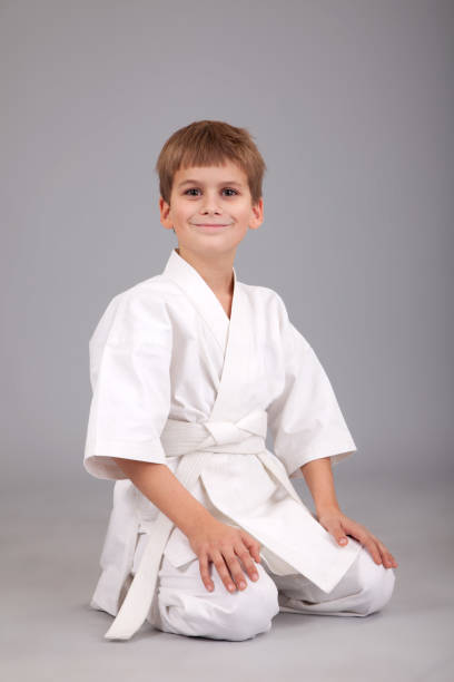 istock Karate boy in white kimono is sitting 1259326253