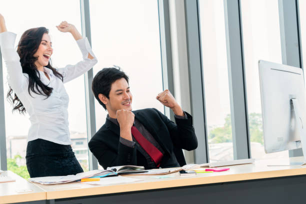 istock Two happy business people celebrate at office 1259334986