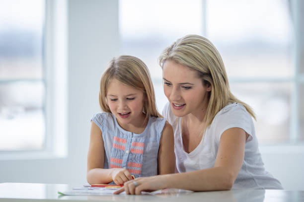 istock Mother helps daughter learn to read at home 1259344328