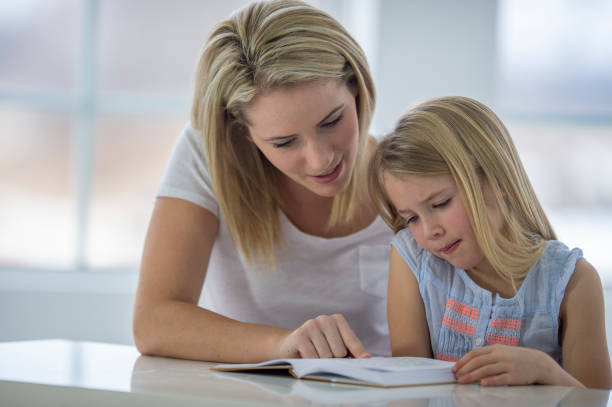 istock Mother helps daughter learn to read at home 1259344332