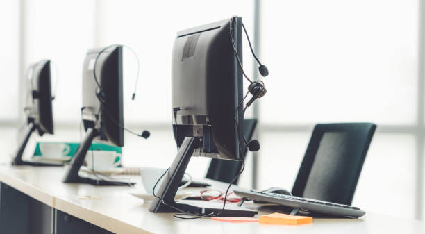 istock Call center computers and headsets all in office 1259358896