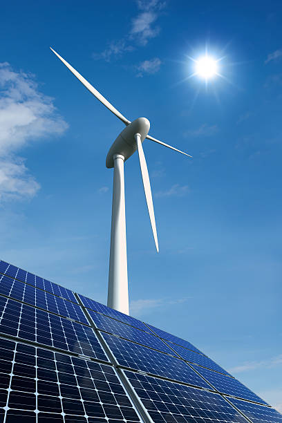 Solar panels and wind turbine against a sunny sky stock photo