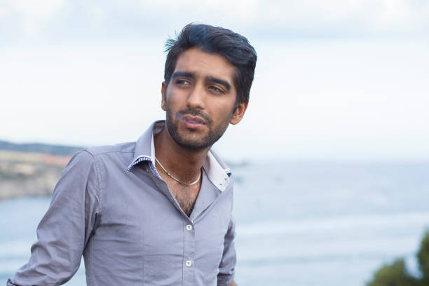 istock Happy ethnic man smoking cigarette, smiling, thinking looking to the side 1259368697