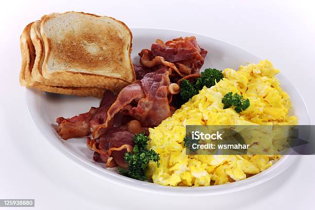 Plate with scrambled egg and bacon on white background Stock Photo - Alamy