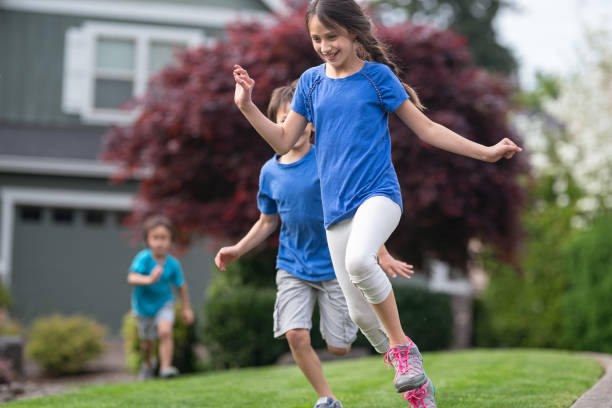istock Three children running outside across a grassy area 1259389291