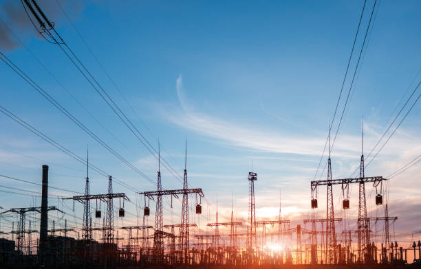 istock Electrical power lines and towers at sunset 1259389865