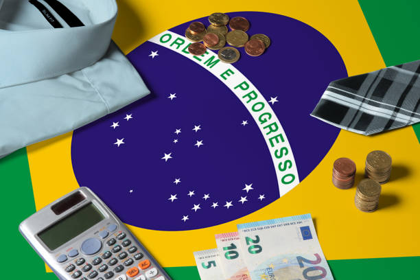 istock Brazil flag on minimal money concept table. Coins and financial objects on flag surface. National economy theme. 1259391524
