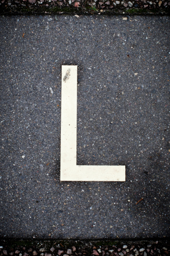 Number 21, legal age, painted on the paved ground of a white-painted parking lot,