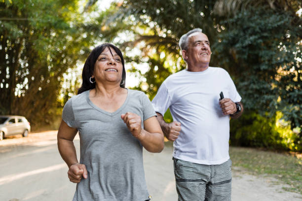 istock Happy senior couple running in public park 1259411977