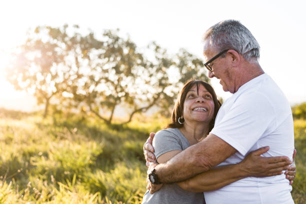 szczęśliwa starsza para ogarnęła patrząc na siebie podczas zachodu słońca - latin american and hispanic ethnicity senior adult mature adult couple zdjęcia i obrazy z banku zdjęć