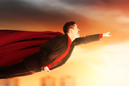 Asian businessman with a cloak flying like a superhero on the sky
