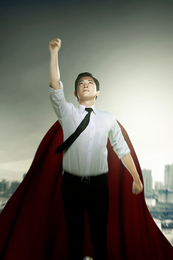 Asian businessman with a cloak flying like a superhero on the sky