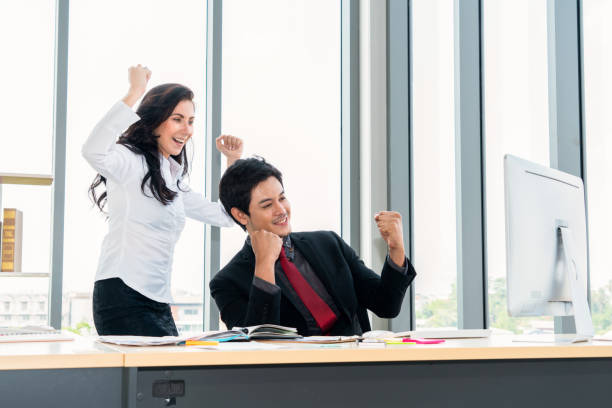 istock Two happy business people celebrate at office 1259519795