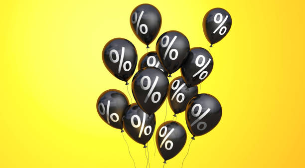 istock Black Friday. Black balloons with a percent symbol on yellow background. Copy space for text. 3D rendering 1259558300