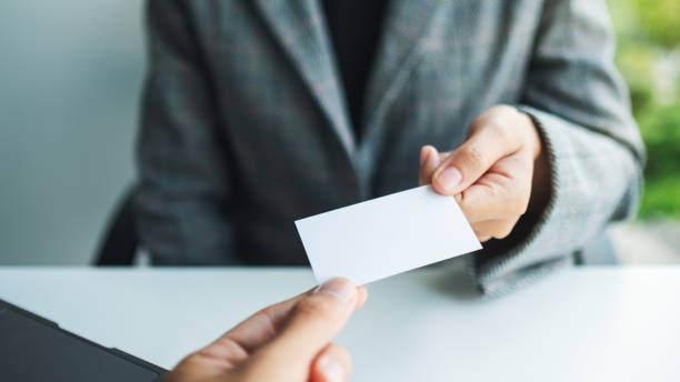 istock Two businessman holding and exchanging empty business card 1259608615