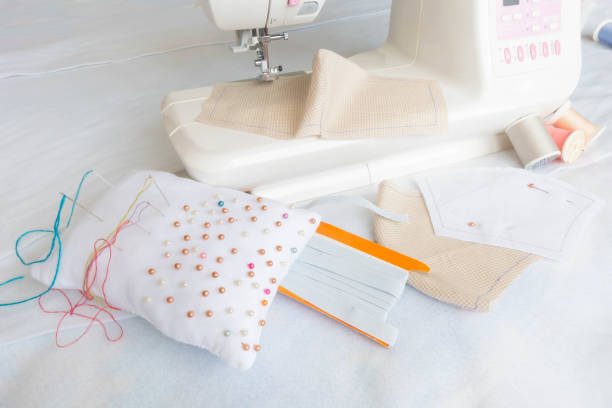 istock Cotton face mask with sewing machine. Making DIY face mask during quarantine for coronavirus pandemic crisis. 1259612674