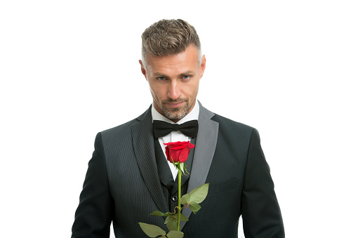 Celebrating womens day. Handsome man hold red rose. Flowers for womens day. Bachelor in formalwear. International womens day. March 8. Floral gift on womens day.