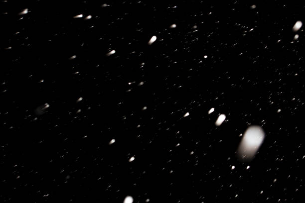 istock first snow in winter on black sky background, abstract blurred photo 1259616272