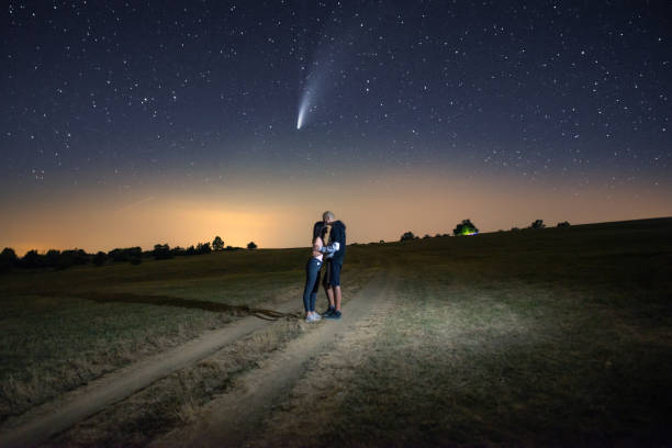 istock Young couple watching the Neowise comet under the bright night sky 1259692714