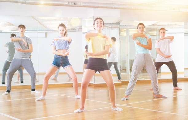 istock Diligent friendly smiling teenagers learn dance movements 1259700092
