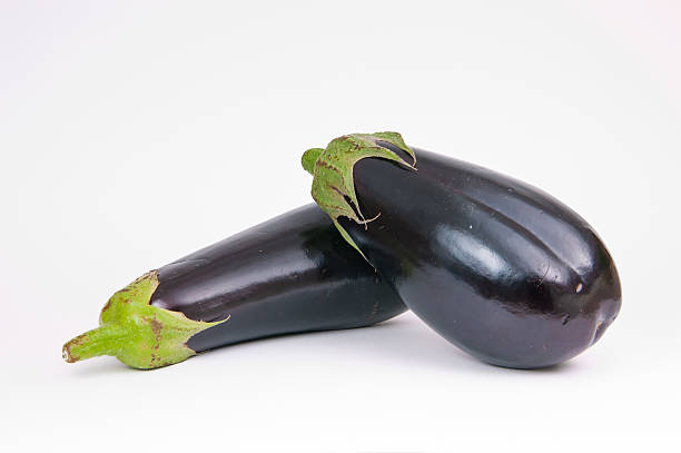 Two isolated aubergines stock photo