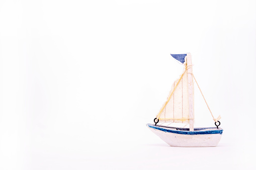 Mini models of colorful, cute and traditional Turkish and Greek sailboats on isolated white background.