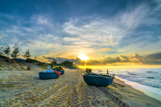Fishing boat to dawn on the beautiful beach on a summer morning on a tropical beach near Mui Ne, Vietnam