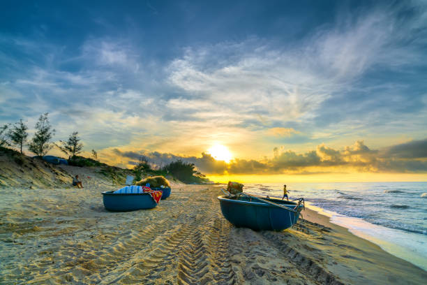 Fishing boat to dawn on the beautiful beach Fishing boat to dawn on the beautiful beach on a summer morning on a tropical beach near Mui Ne, Vietnam mui ne bay photos stock pictures, royalty-free photos & images