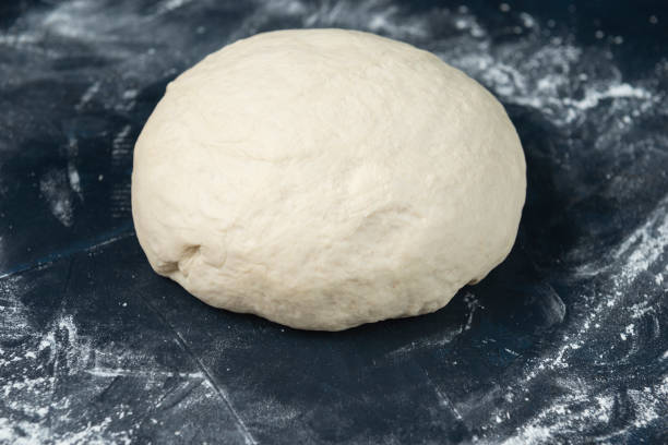 istock A piece of yeast dough on blue textured table. Process of making bakery. 1259787683