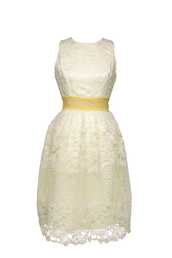 Lacy dress isolated. Closeup of a white yellow stylish sleeveless evening dress with lace on mannequin isolated on a white background. Summer fashion.
