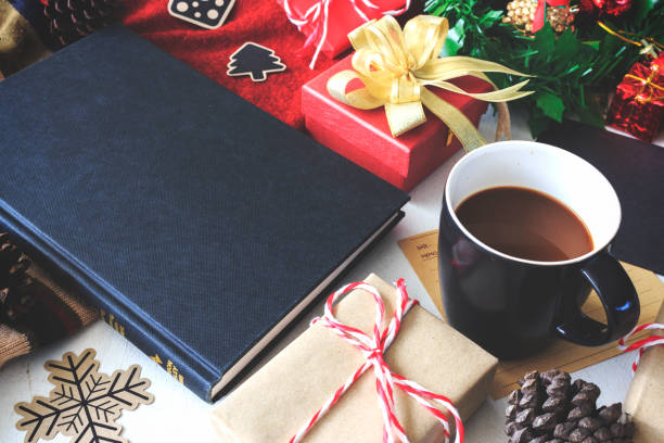 istock Composition of book with cup of coffee and Christmas decorations on table, over light 1259791575