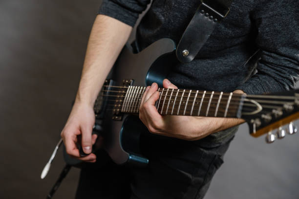 istock Male hands playing electric guitar 1259800305