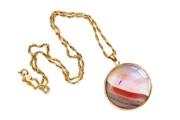 Elegant large pink mineral pendant on gold chain isolated over white
