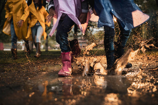 istock Unrecognizable kids running through muddy puddle in nature. 1259806886