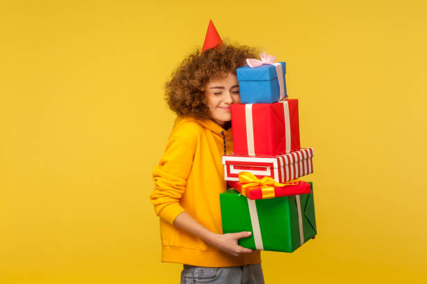 emozioni felici dalla grande montagna di doni. ritratto di felice donna dai capelli ricci con cono da festa - gift box foto e immagini stock