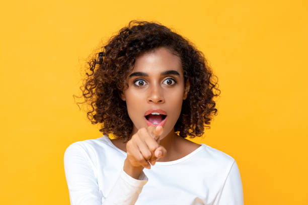 istock Attractive young African American woman looking shocked while pointing finger at front 1259863712