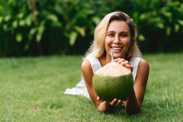 istock Coconut and women relax time on the green grass. 1259875662