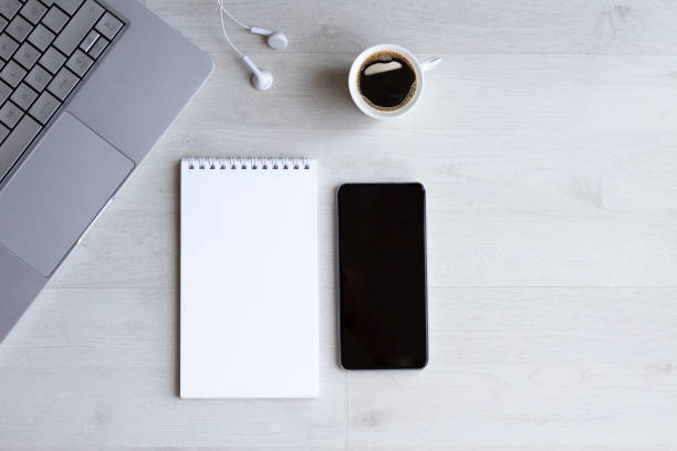 istock Office desk table with laptop, notebook, phone, coffee cup and earphones 1259877287