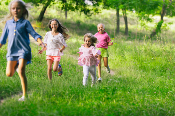 istock Kids, children running on meadow in summer's sunlight 1259890111