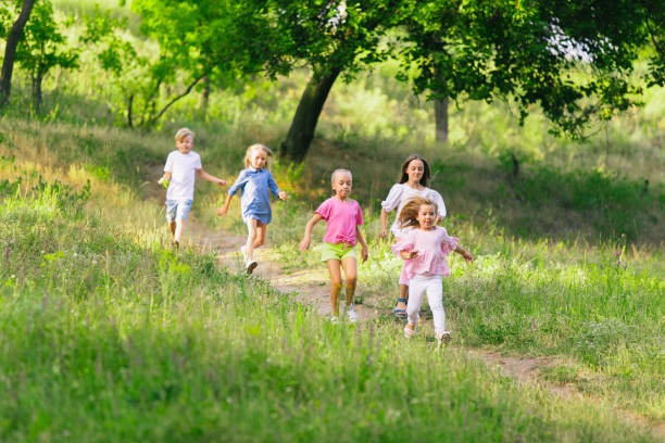 istock Kids, children running on meadow in summer's sunlight 1259890114