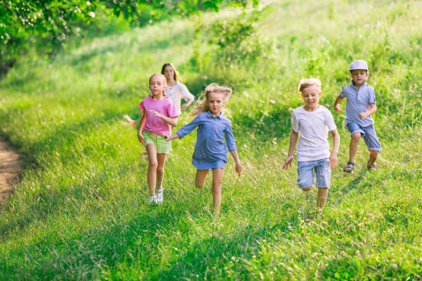 istock Kids, children running on meadow in summer's sunlight 1259890119