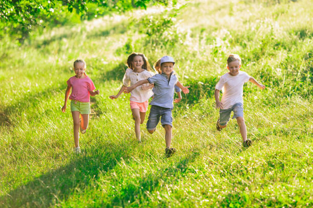 istock Kids, children running on meadow in summer's sunlight 1259890567
